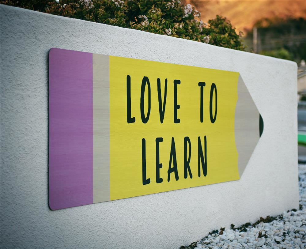  A sign with a Pencil on it stating Love to Learn.